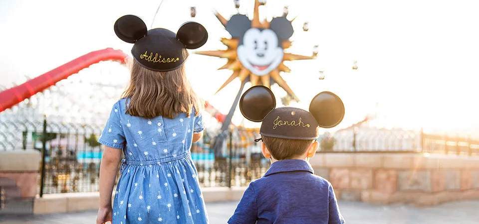 Children wearing colorful Disney ears headbands.